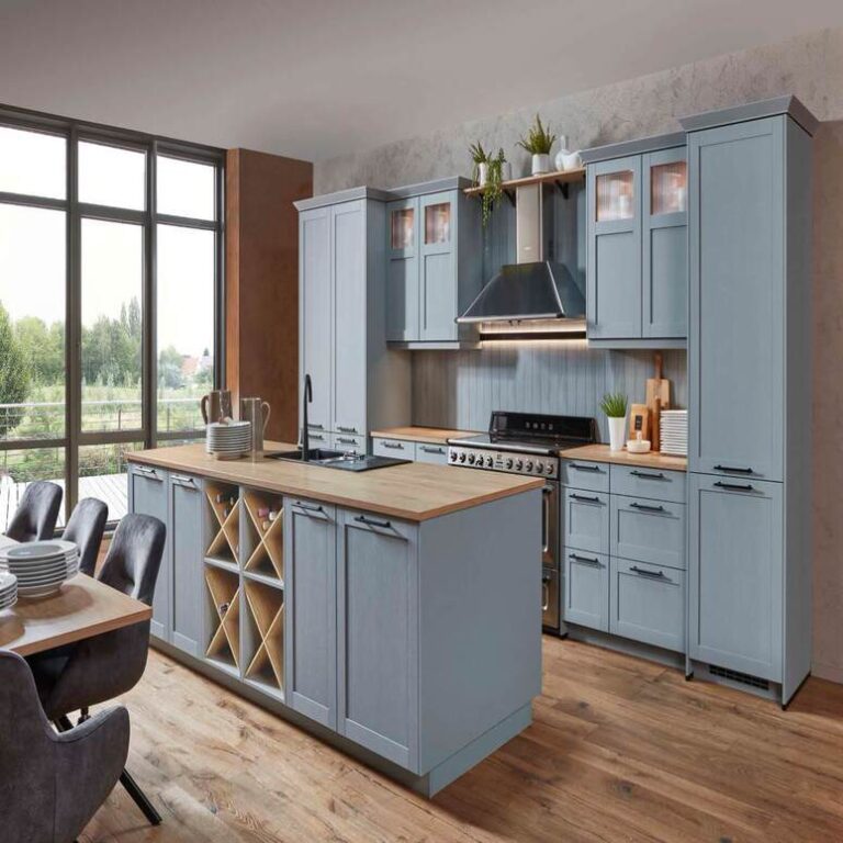 Hellblaue Landhausküche Landhausküche in Hellblau mit Vitrinenschränken, Kochinsel und Holzarbeitsplatte – Küchenstudio Magdeburg