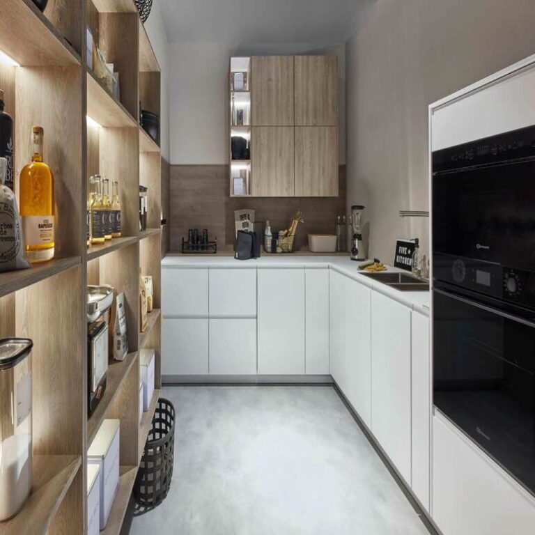 Moderne weiße Küche – Küchenstudio Magdeburg Moderne weiße Küche mit Hochschränken, Holzregal und schwarzen Einbaugeräten